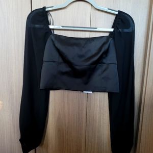 Black satin crop top with sheer sleeves.